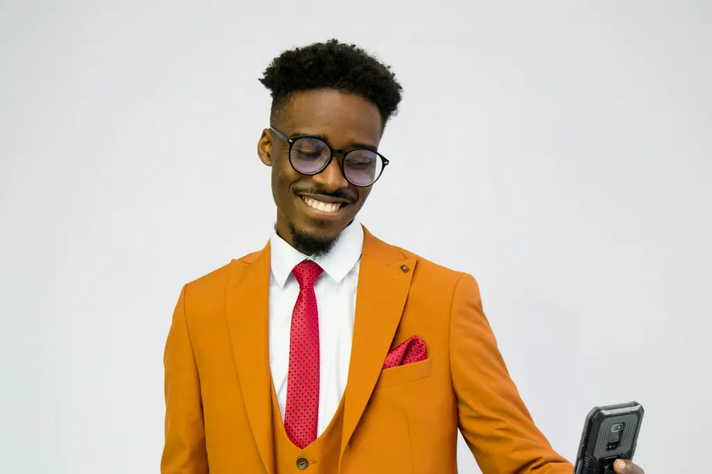Professionnel en costume orange consultant son profil sur son téléphone